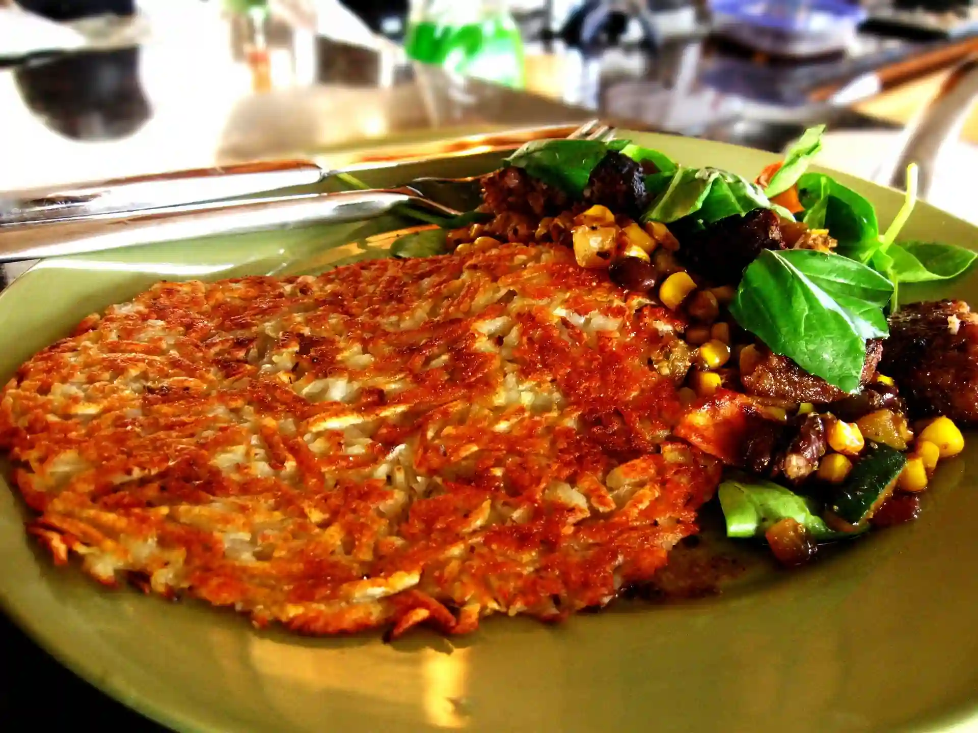 A hashbrown plated with a salad.