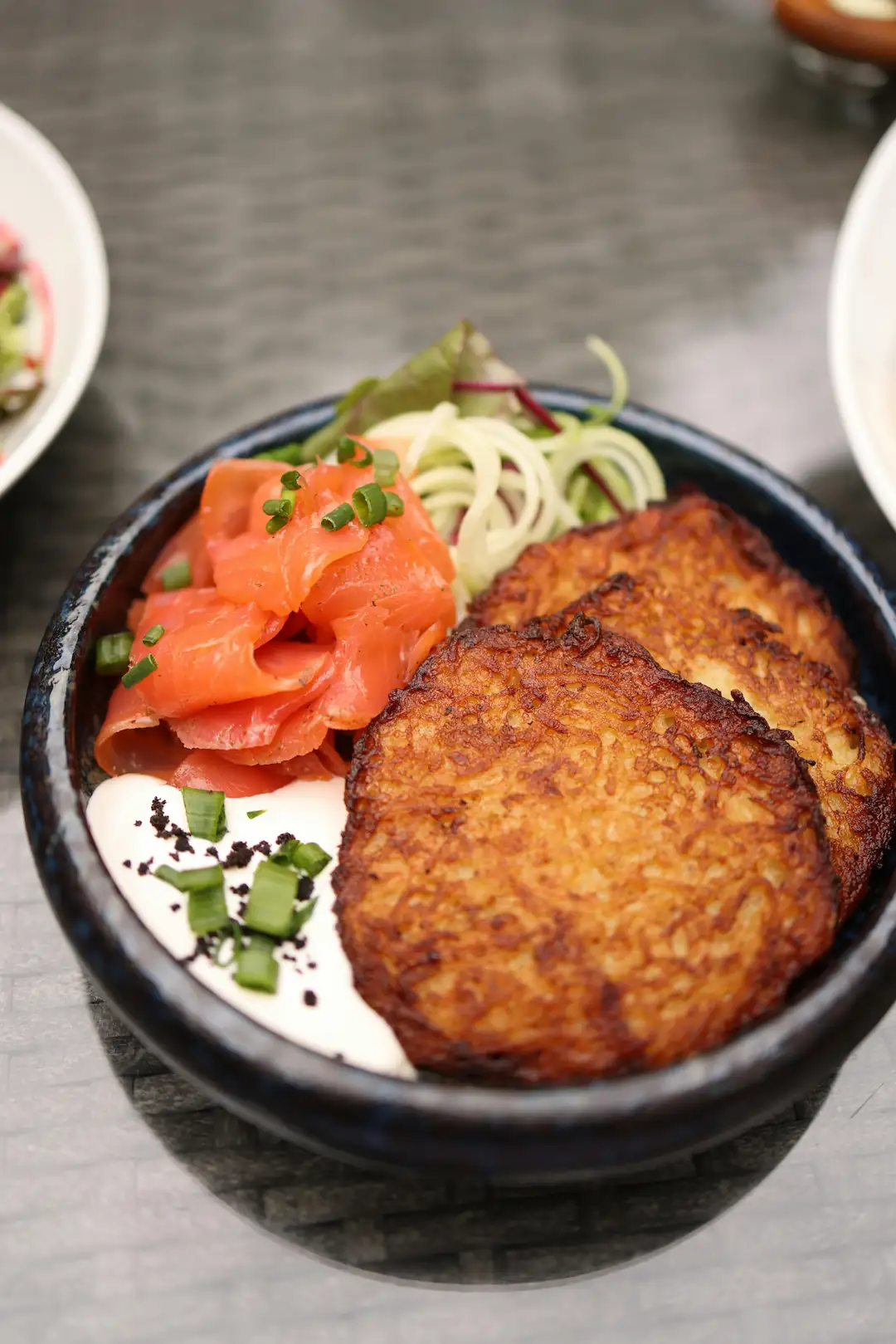 Hashbrown plates with some vegetables and sour cream.
